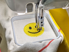 die Stickmaschine stickt einen Smiley