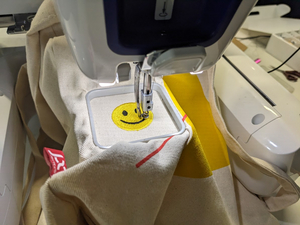 die Stickmaschine stickt einen Smiley