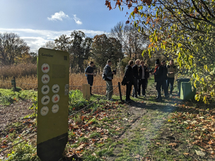 Studierende und die Kursleitung erhalten eine Führung über den Acker