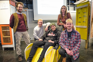 Alexandre Bailly mit dem Projektteam Future Furniture. Die Studierenden sitzen auf einem selbst gebauten Möbelstück mit einer Sitzfläche aus Fahrradschläuchen.