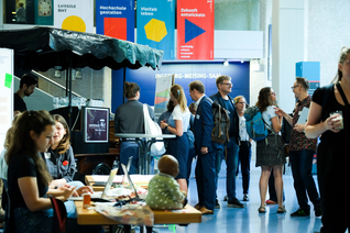 Infostand und Gruppen von Menschen im Foyer Haus Grashof der BHT