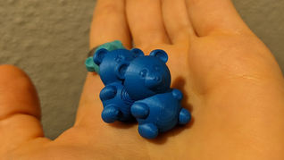 zwei kleine 3D-gedruckte Gummibärchen auf einer Hand
