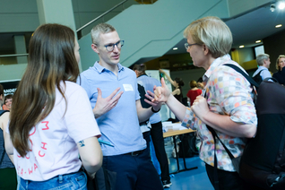 Drei Menschen im Austausch im Foyer Haus Grashof der BHT