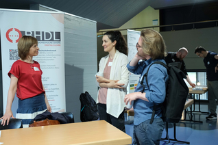 Drei Frauen im Gespräch an einem Infostand